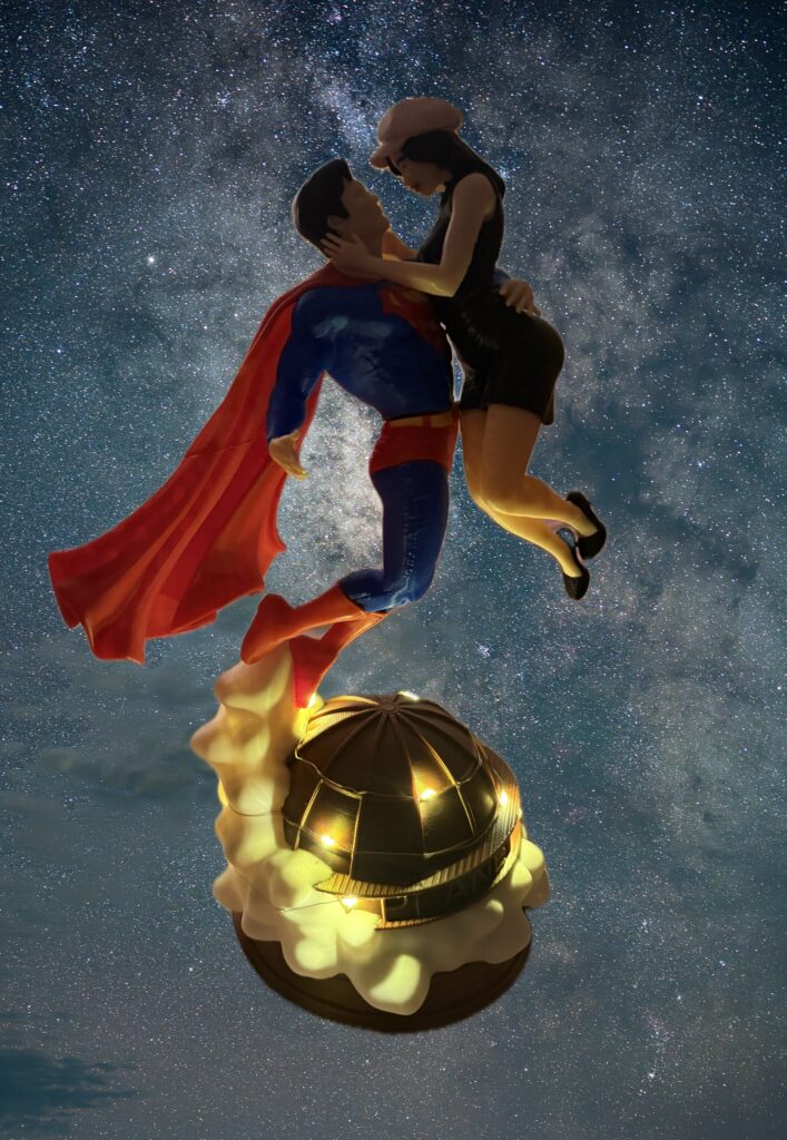 Figura iluminada de Superman y Lois flotando en el cielo estrellado, con la cúpula del Daily Planet encendida bajo sus pies